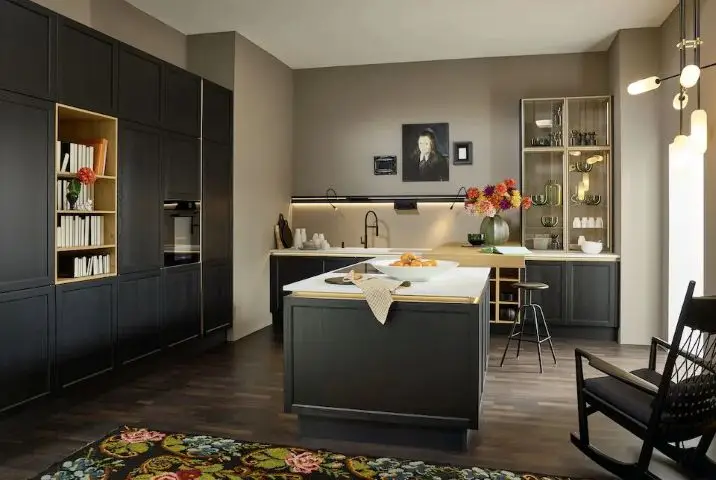 Dark Nolte kitchen with island and lit open shelving